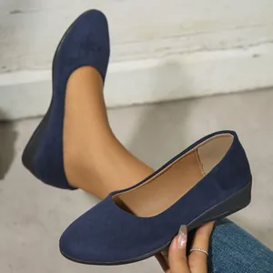 Close-up of dark blue suede wedge flats showing soft texture and comfortable slip-on fit.