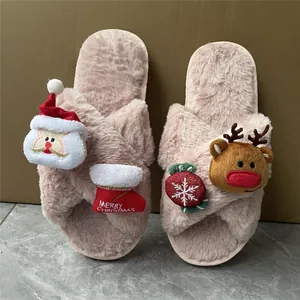 Dettaglio di pantofole natalizie in peluche rosa con decorazioni a tema Babbo Natale