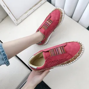 Détail de mocassins plats rouges respirants et ajourés avec une bande élastique colorée