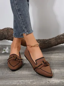 Detailed close-up of brown breathable flyknit flat shoes featuring a stylish black bow