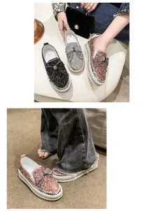Primo piano di mocassini glitterati con fiocco di strass e suola platform cucita a mano.