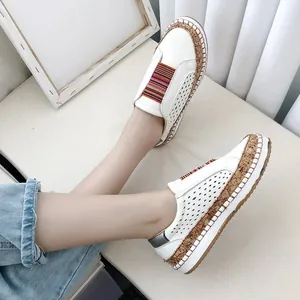 Vue détaillée de chaussures plates blanches ajourées avec élastiques colorés.