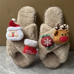 Primo piano di calde pantofole natalizie in peluche con decorazioni di Babbo Natale