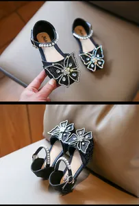 Detailed view of black glitter girls' sandals featuring pearl straps and a butterfly.