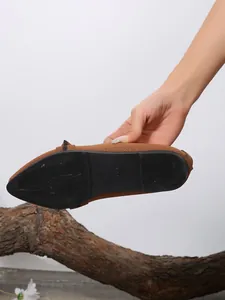 Macro view of the durable black rubber sole and breathable brown flyknit fabric on flat shoes.