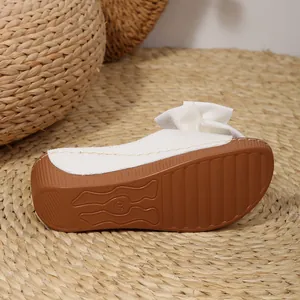 Detailansicht der weißen Plateauslipper für Damen mit Schleife und Sohlenprofilierung