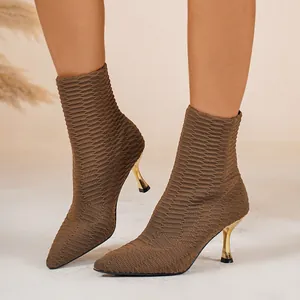 Nahaufnahme brauner Strickstiefeletten mit spitzer Kappe und goldenem Stöckelabsatz.