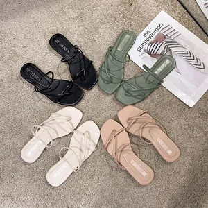 Set di sandali infradito piatti da donna in quattro colori su un tappeto grigio