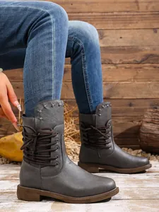 Detailansicht grauer Damenstiefeletten mit modischer seitlicher Schnürung am Bein