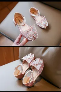 Detail view of pink girl's princess sandals with rhinestone butterfly bow and pearl strap