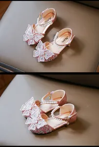Detailed view of pink glitter girls princess sandals featuring pearl straps and butterfly bows