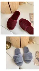 Vue détaillée des chaussons en fausse fourrure gris et bordeaux pour l'intérieur de la maison