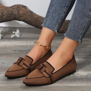 Close-up of brown fly-knit pointed-toe flats with bow detail and black trim