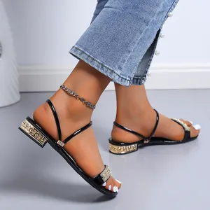 Detalle de sandalias negras elegantes con tiras de diamantes de imitación y tacón bajo