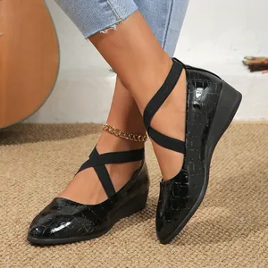 Detail view of women's black crocodile pattern pointed toe wedge shoes with straps
