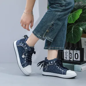 Close-up of women's blue polka dot high-top sneakers with lace-up and zipper details