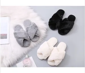Detailed view of plush cross-strap slippers in grey, black, and white colors