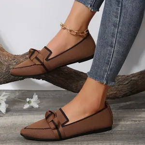 Detailed view of brown flyknit pointed-toe flat loafers featuring a stylish bow detail