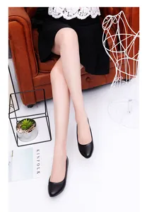 Detailed view of elegant black round-toe low-heel professional work shoes on model