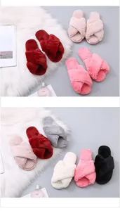 Multiple colors of soft cross strap fuzzy slippers displayed on a white fur rug