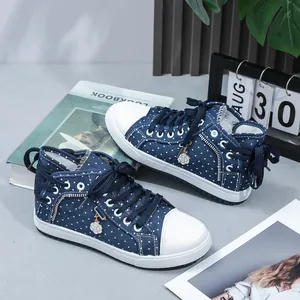 Side detail view of navy blue high-top polka dot sneakers with cute flower charm