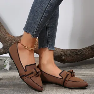 Detailed view of women's breathable brown flyknit flats with bow detail worn by model