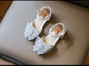 Detailed view of silver glitter girls sandals with elegant butterfly bow and pearls