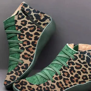 Detailed view of women's leopard print Martin boots with green suede panels and side zipper