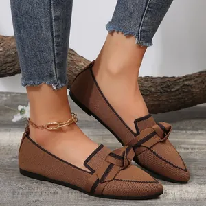 Detailed macro view of breathable brown fly-woven flat shoes featuring a stylish bow and pointed toe