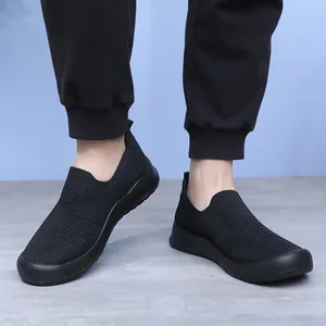 Vue détaillée des chaussures de marche sans lacets en maille noire pour hommes portées