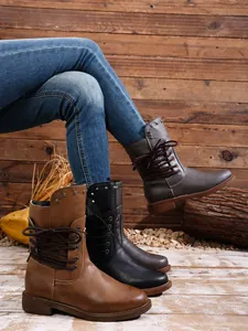 Detailansicht stilvoller Damen-Schnürstiefeletten in verschiedenen Farben auf Holz.