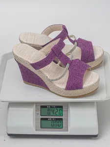 Nahaufnahme violetter Plateau-Keilsandalen auf einer Waage mit 0,42 kg Gewicht.