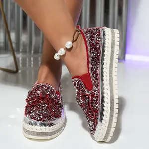 Detail of red rhinestone slip-on loafers with sparkling bow and thick white sole