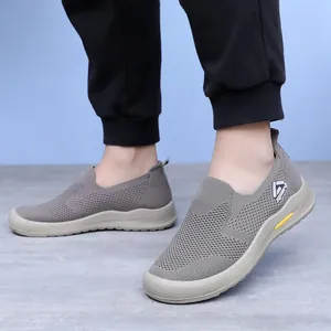 Gros plan de chaussures de marche grises en maille respirante pour hommes porté