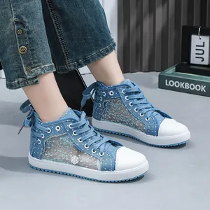 Close-up of blue denim high-top sneakers featuring lace mesh panels and white rubber soles