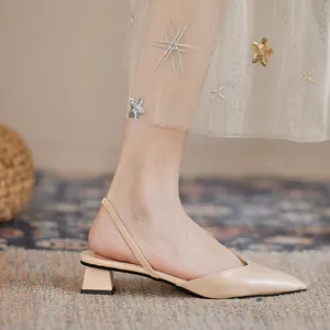 Πλάγια όψη μπεζ slingback γόβες με μυτερή μύτη και χοντρό τακούνι φορεμένες σε μοντέλο