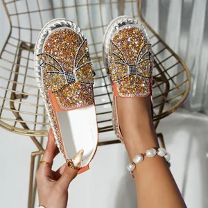Detailed view of women's loafers with sparkling rhinestones and a large bow accent