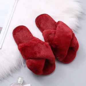 Close-up of red faux fur criss-cross slippers with soft warm plush texture details.