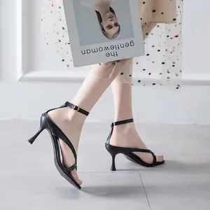 Elegant black stiletto sandals with ankle strap shown on model for fashion display