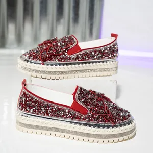 Close-up detail of luxury red rhinestone platform loafers with elegant butterfly bow