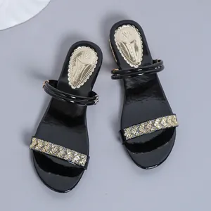 Vista superior de elegantes sandalias negras de tacón medio con tiras de strass brillo.