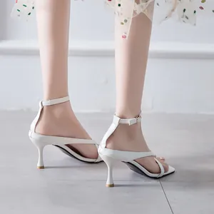 Elegant white kitten heel sandals with ankle straps, shown from a side-back view.