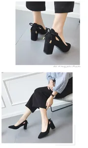 Elegant black suede chunky heel pumps with stylish heel bow detail shown on model.