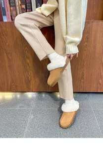 Detailed view of camel fuzzy slippers with white faux fur lining on a lifestyle model.