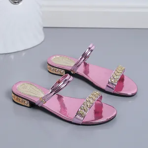Detalle de sandalias metalizadas rosas con adornos de strass en la tira