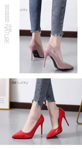 Detailed view of glossy pink and bright red pointed-toe stiletto high heels on a model
