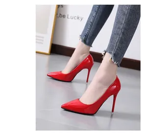Stylish red patent leather pointed-toe stiletto high heels worn in a lifestyle setting