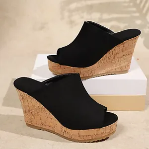 Close-up of black suede wedge sandals with cork platform and peep-toe design