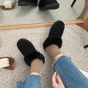 Cozy black fur-lined loafers worn with jeans on a stylish rug