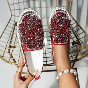 Detailed view of women's loafers featuring sparkling red and silver rhinestone bows